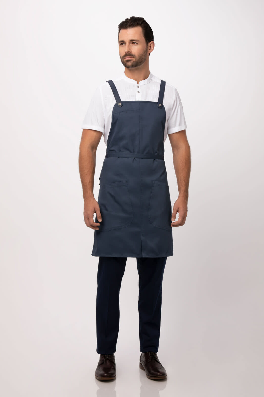 A navy blue Largo Bib Apron worn by a man, featuring adjustable straps and a sleek design.
