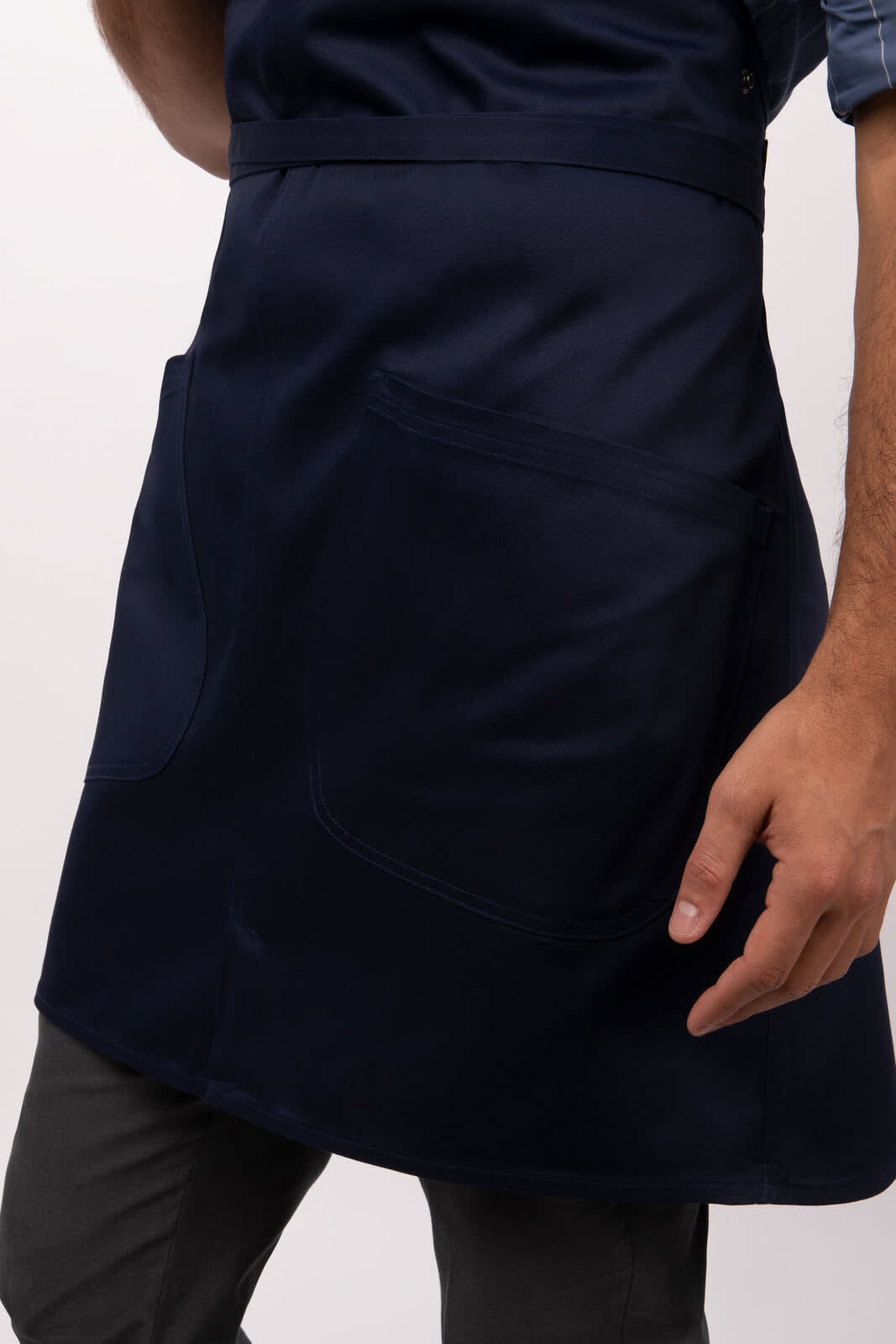 A navy blue bib apron featuring two large pockets and a branding logo.