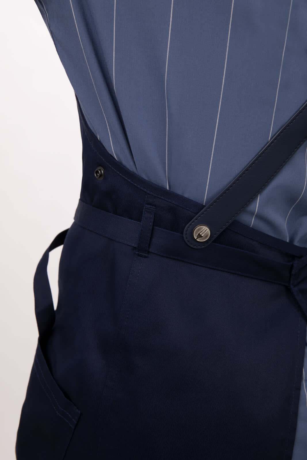 A navy blue bib apron with pinstripe detailing and adjustable straps, featuring a side pocket and button closures.
