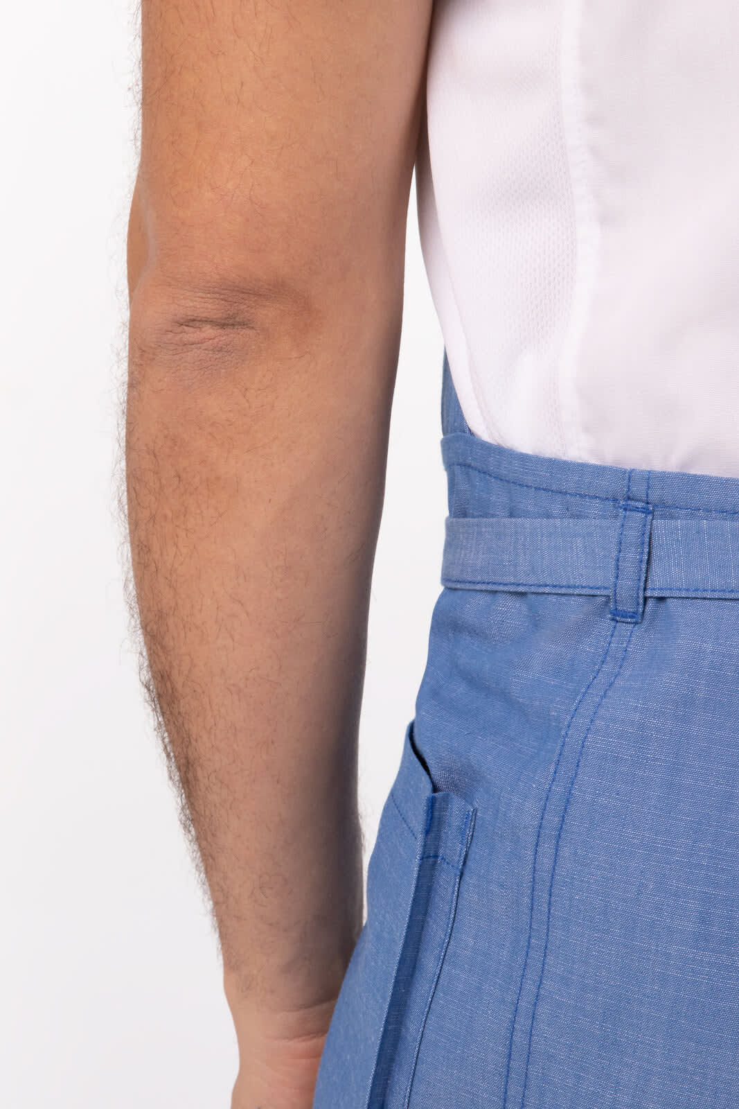 A close-up of a person's arm alongside a blue Medford bib apron with a structured design.