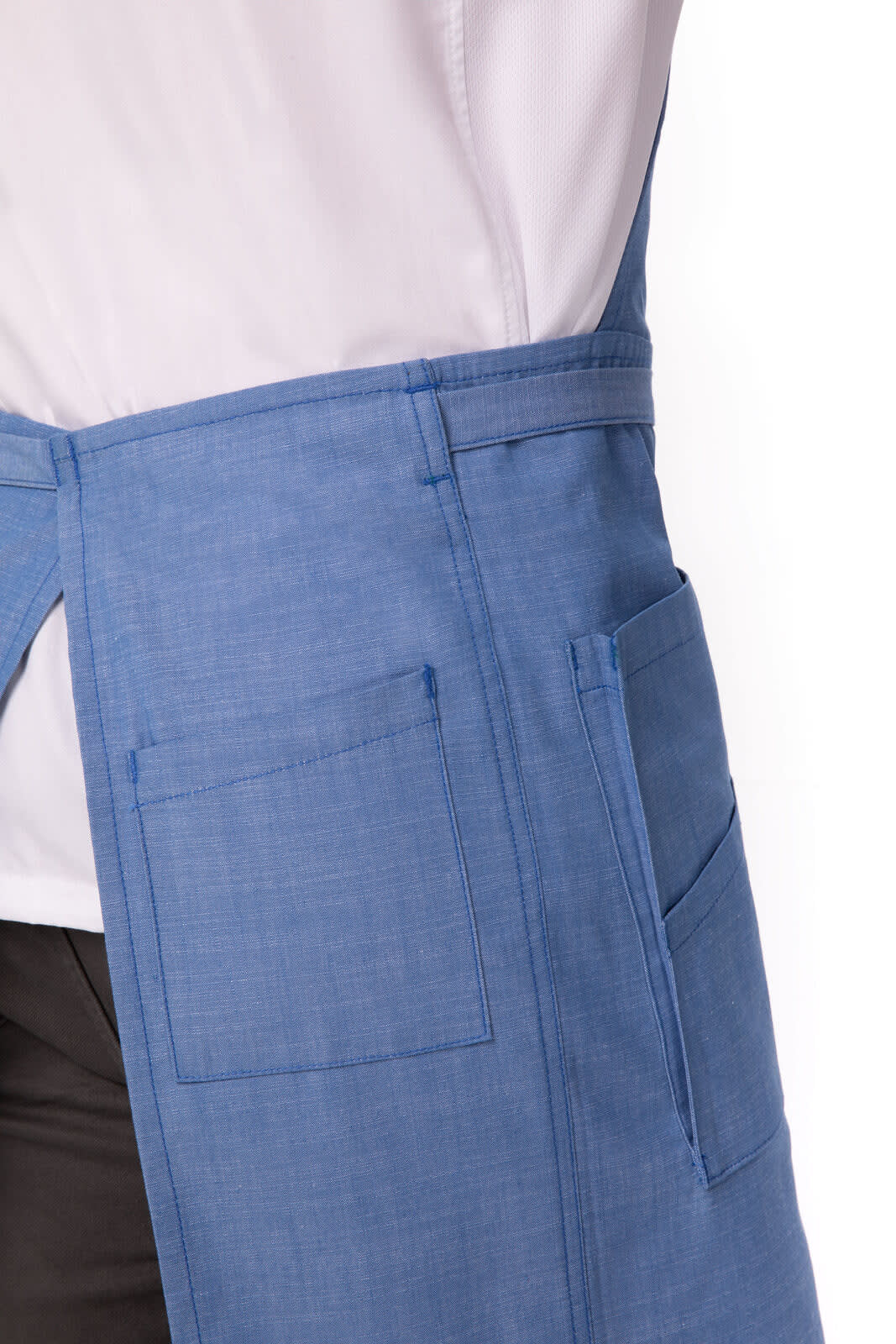 A blue bib apron featuring multiple pockets and a tie at the back, displayed on a light-coloured shirt.