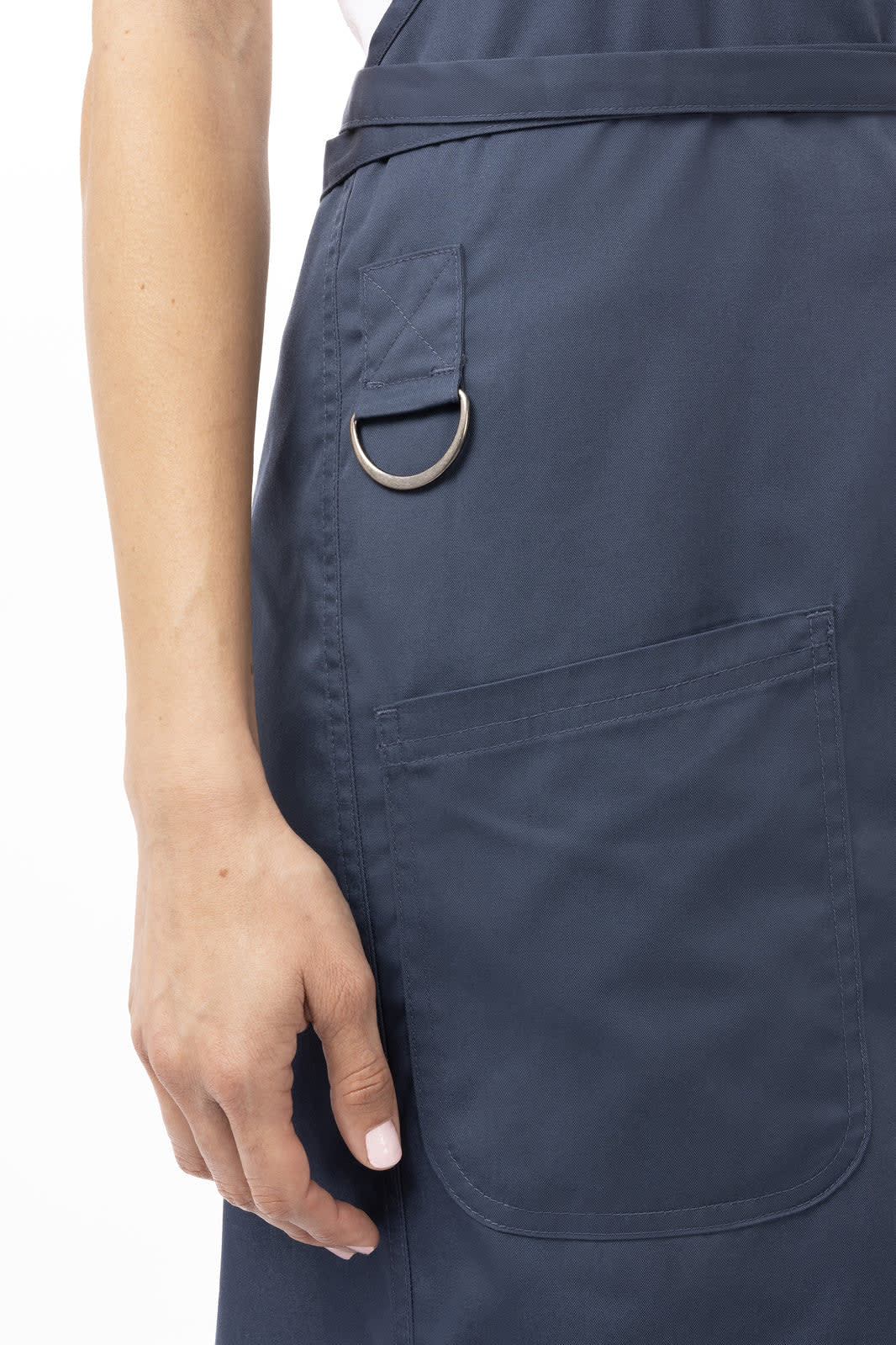A navy blue bib apron featuring a side pocket and a metal ring detail.