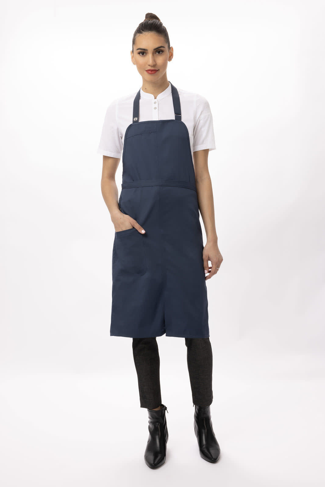 A navy blue bib apron featuring a front pocket, worn by a model with a high bun and white shirt.