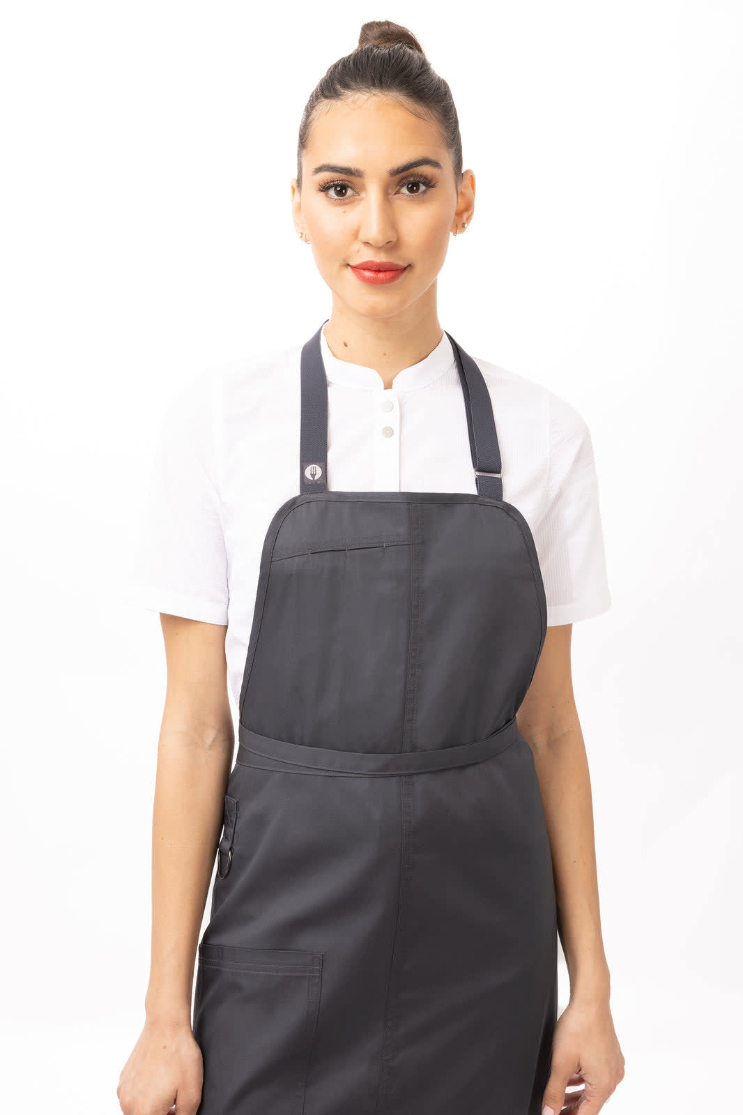 A woman wearing a black Brio Bib Apron over a white shirt, featuring a logo on the apron.