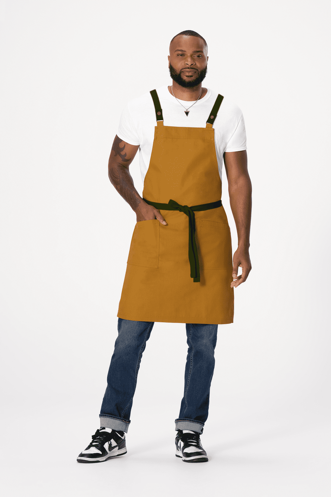 A man wears a mustard yellow Lockharte Cross Back Apron with a black waist tie, featuring a logo.