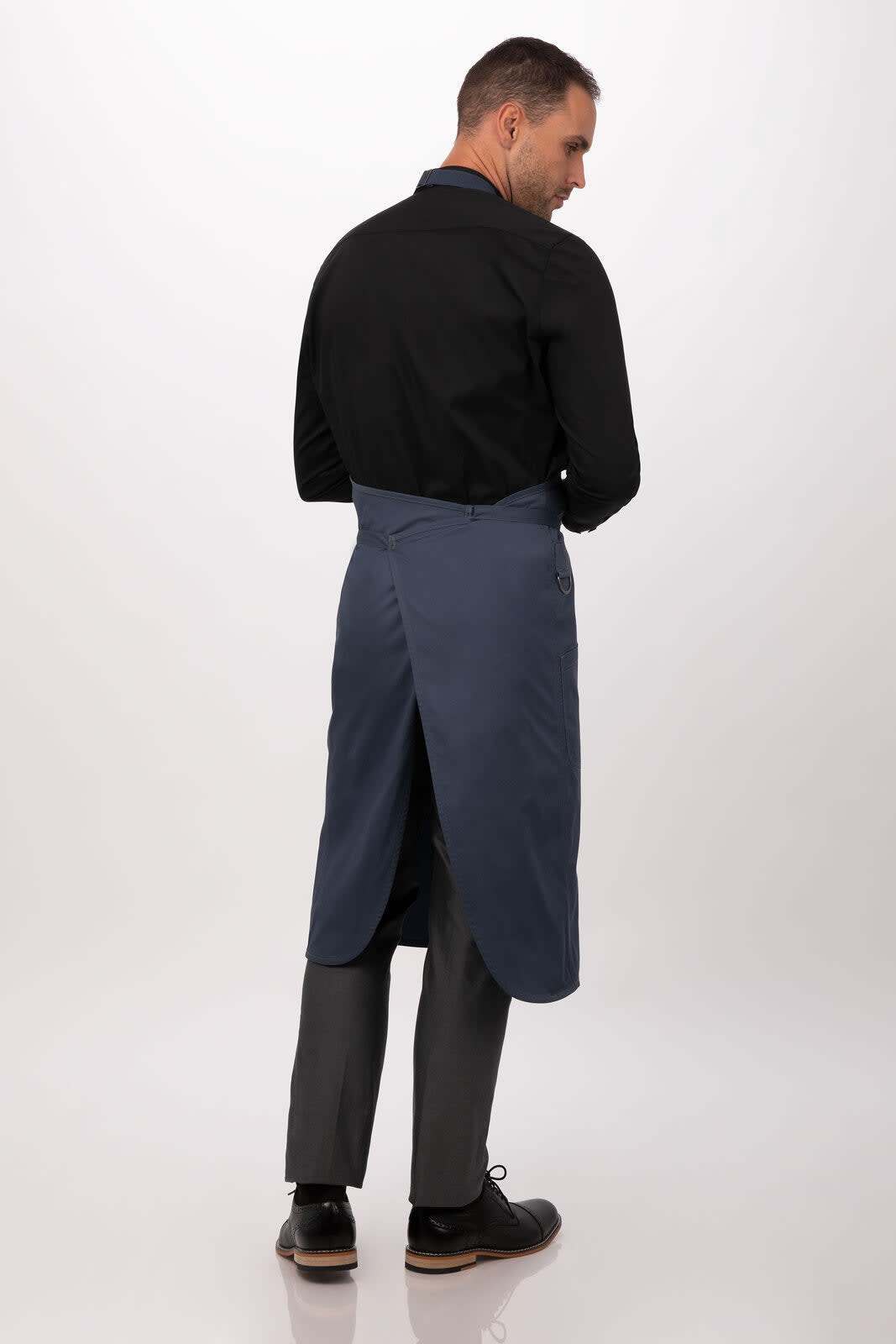 A blue bib apron worn by a person, featuring a back opening and a black long-sleeve shirt.