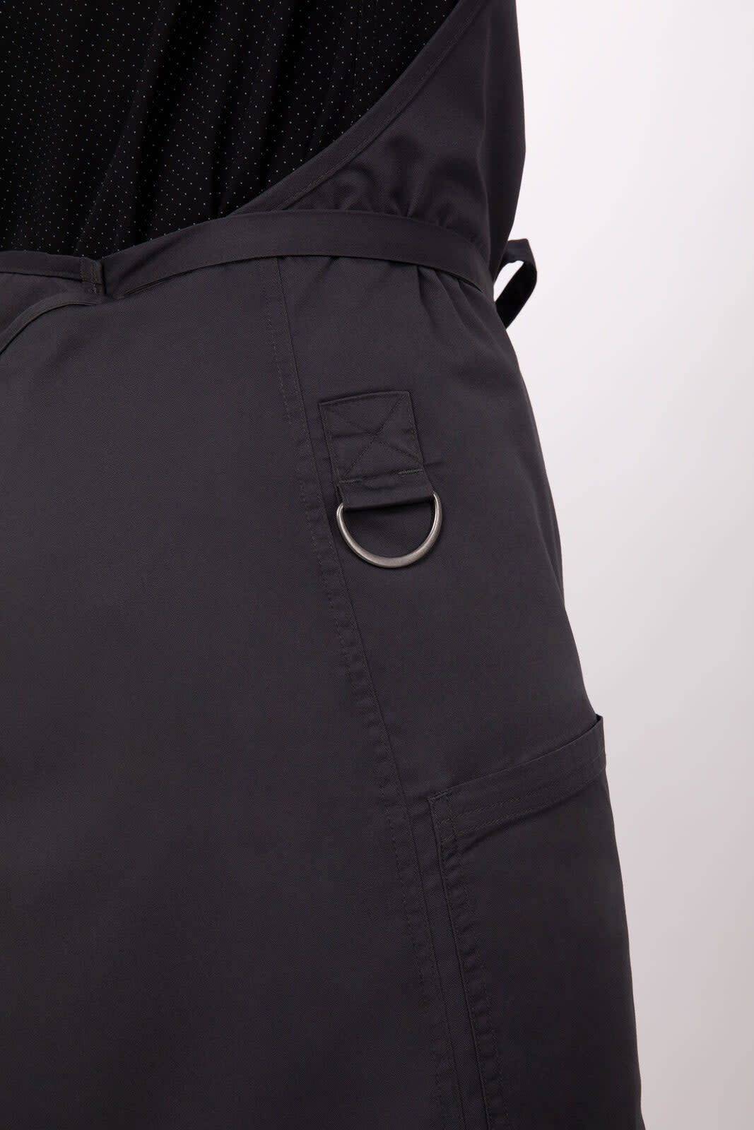 A black bib apron featuring a pocket and a metal ring detail, designed for workwear use.