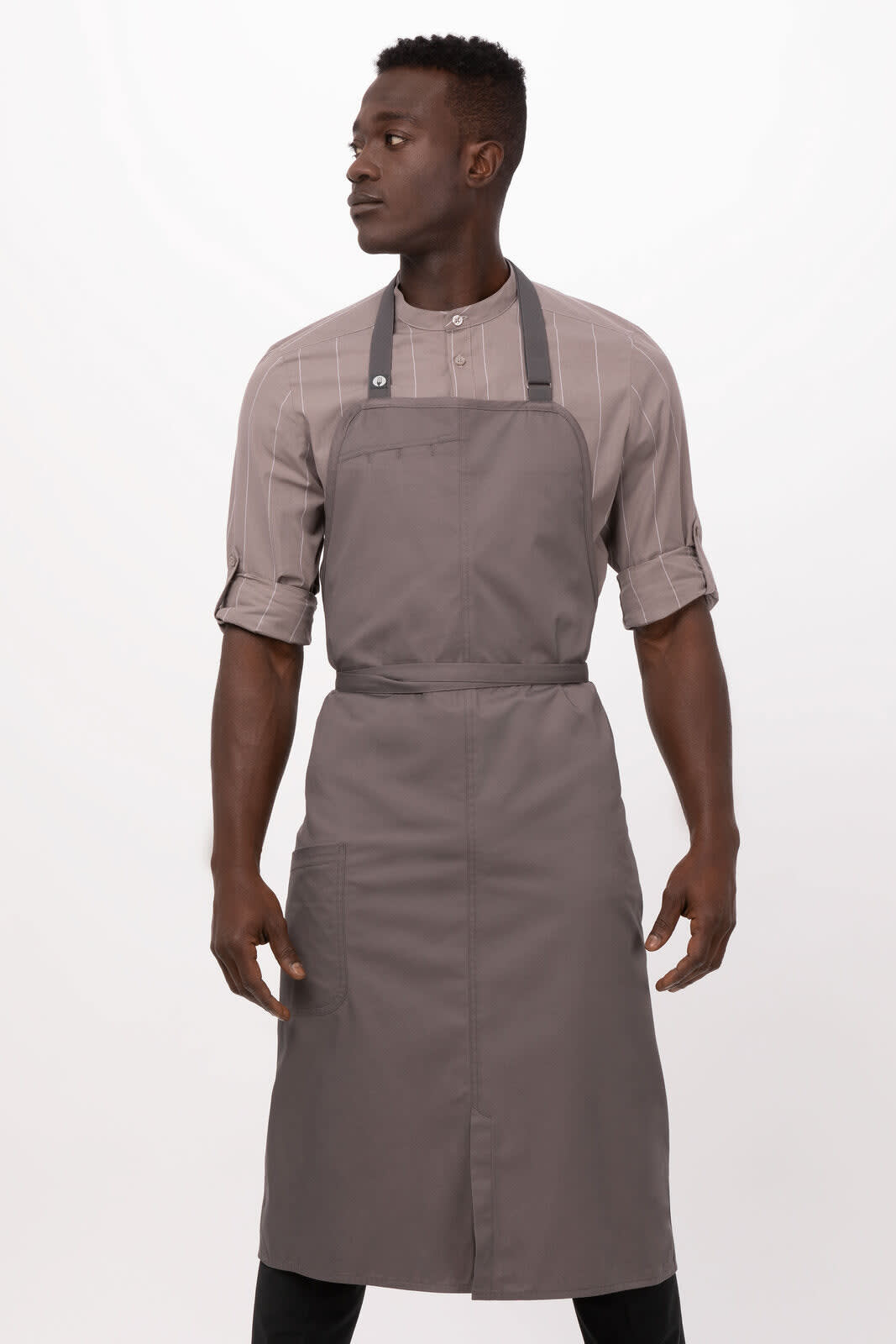 A grey bib apron with adjustable straps, worn by a model. The apron has a simple design and includes a logo.