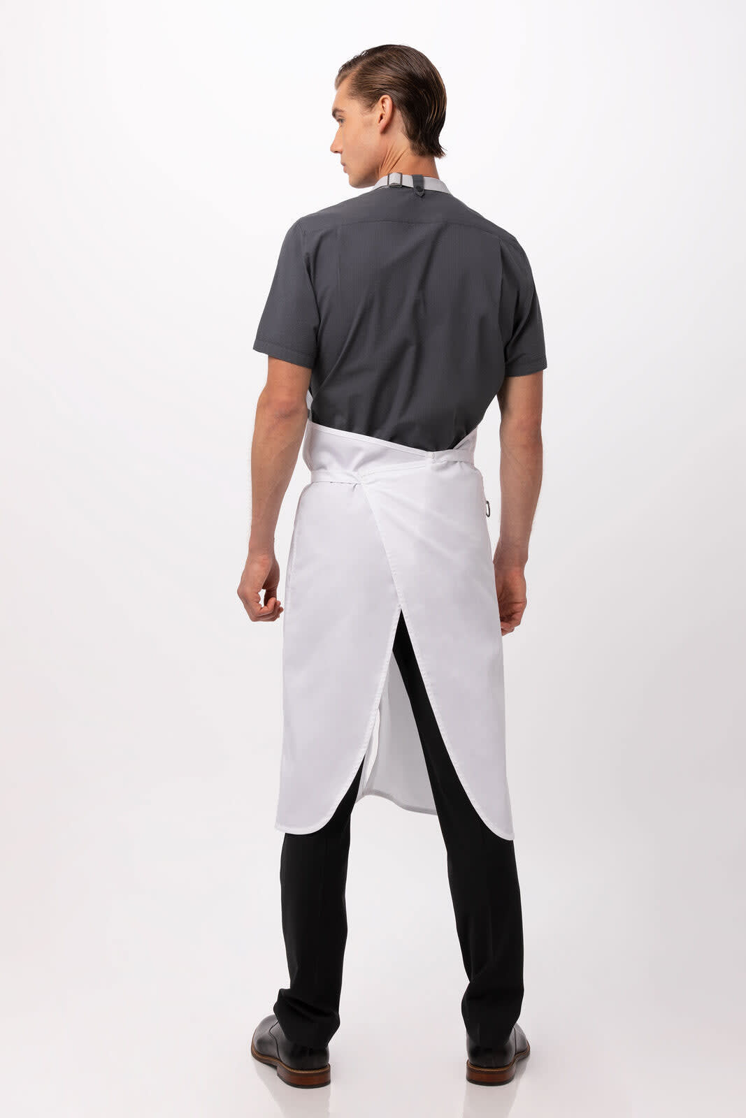 A white bib apron worn over a grey shirt, featuring an adjustable neck strap and a simple design.