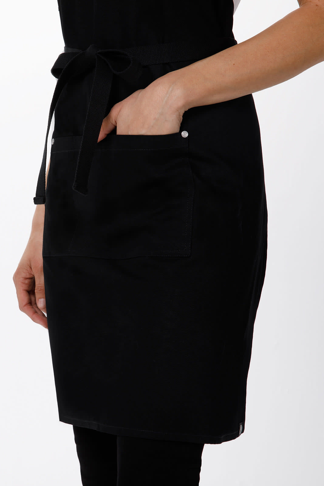 A black cross-back apron with a front pocket and adjustable tie, featuring a simple design and overall sleek appearance.