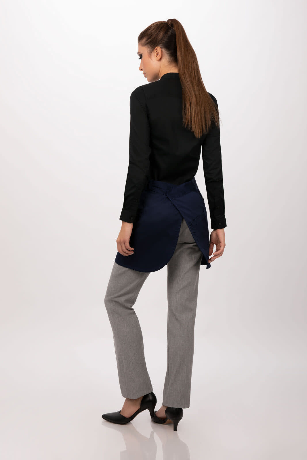 A navy half bistro apron worn over grey trousers, paired with a black top and shoes, featuring a branding logo.
