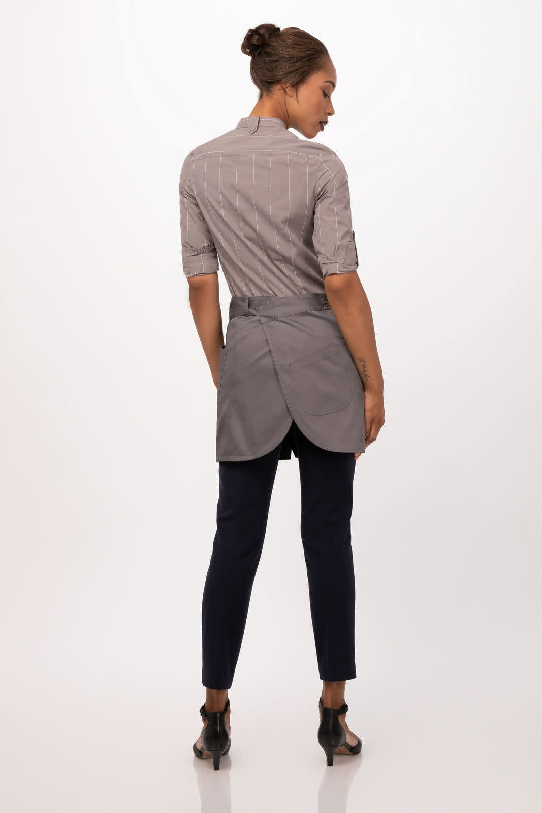 A grey half bistro apron worn over a striped shirt, paired with dark trousers and high-heeled shoes.