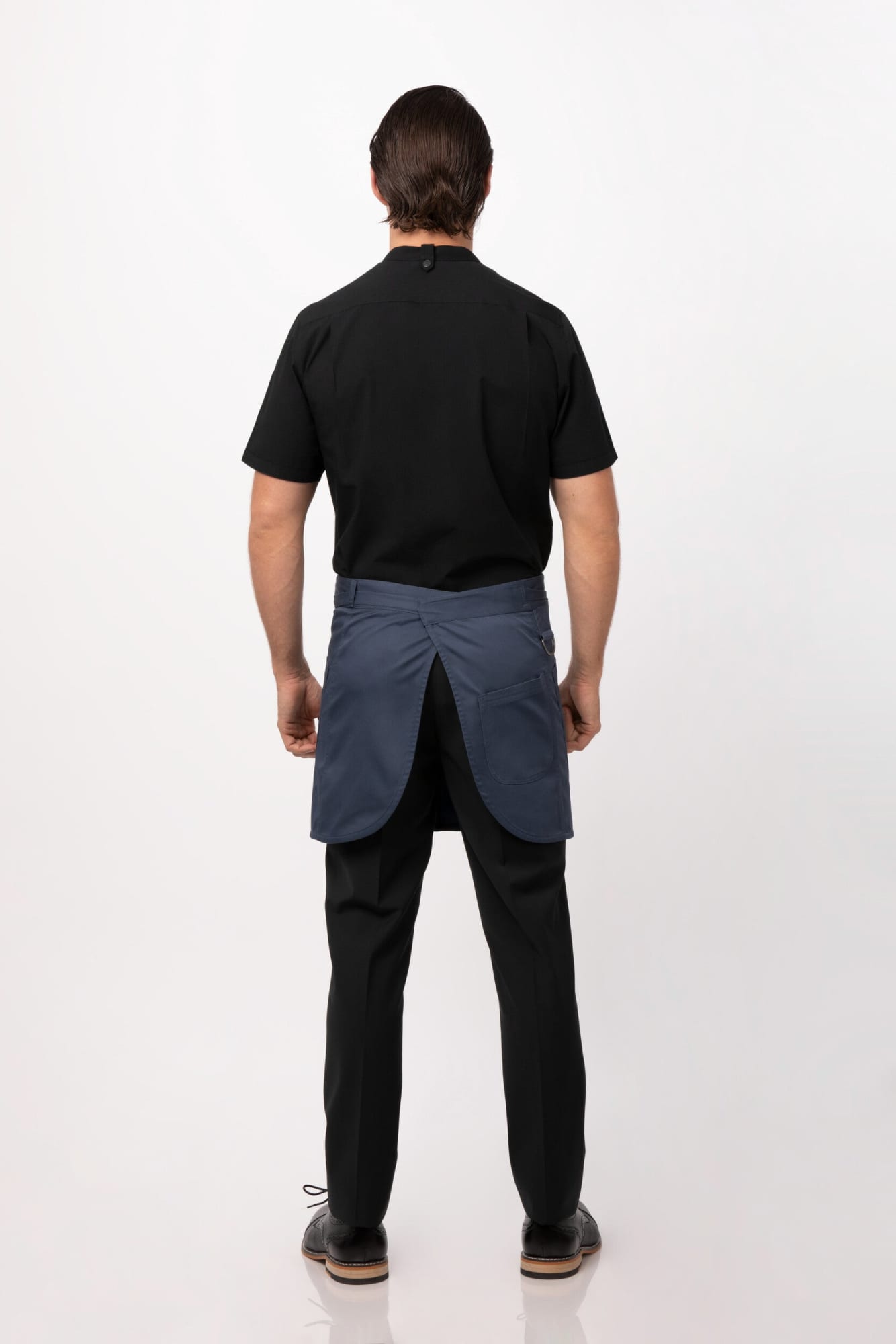 A navy half bistro apron worn by a person, viewed from the back, paired with black workwear.