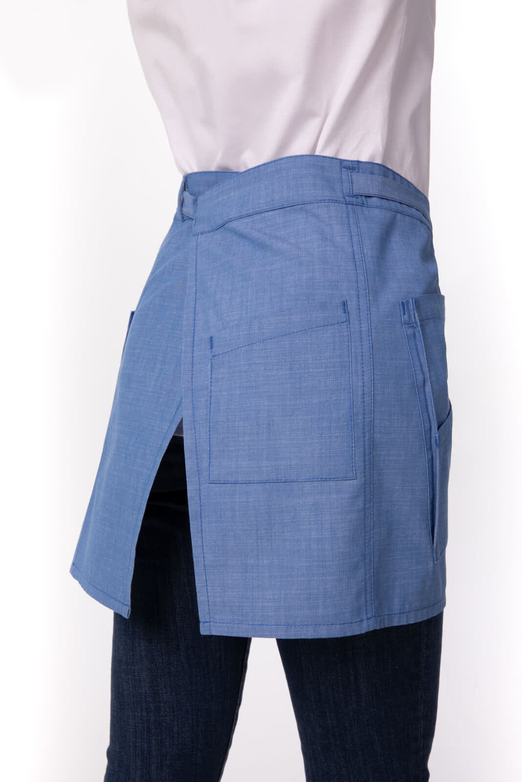 A blue half bistro apron with pockets, featuring a side split, displayed on a model.