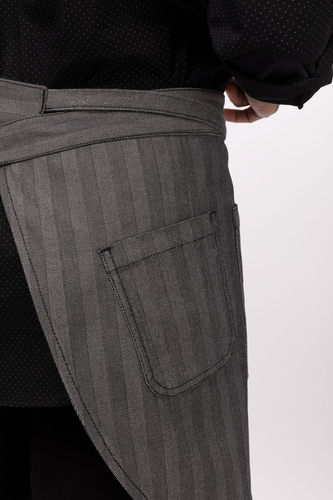 A grey striped bistro apron featuring a side pocket and tied at the waist, with a person wearing it.