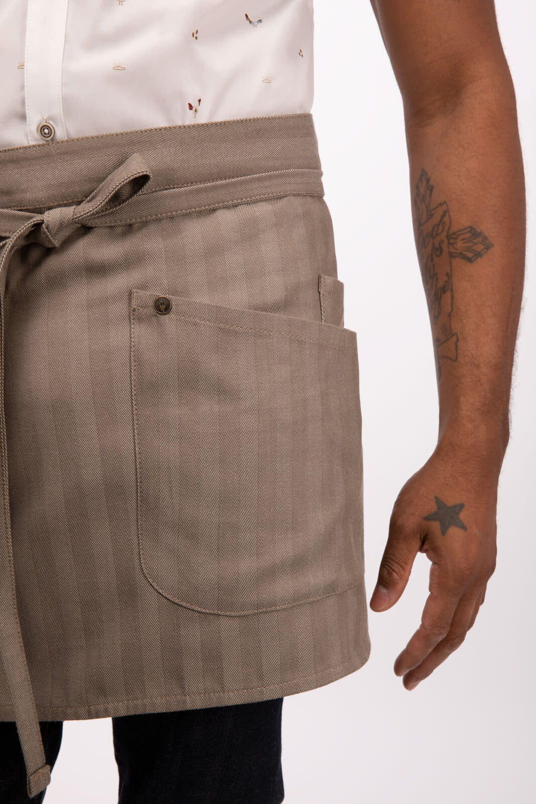 A bistro apron in a light brown, featuring a pocket and an adjustable tie at the waist.