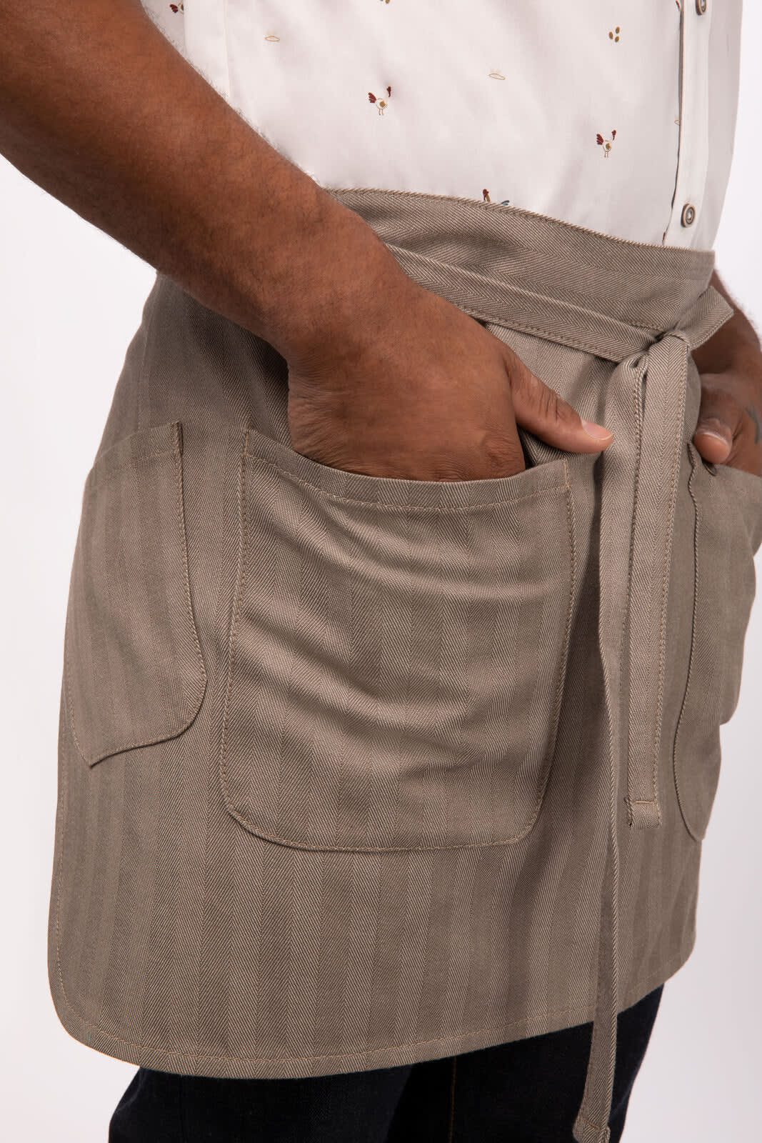A beige bistro apron with pockets and a tied waist, featuring a subtle striped design.