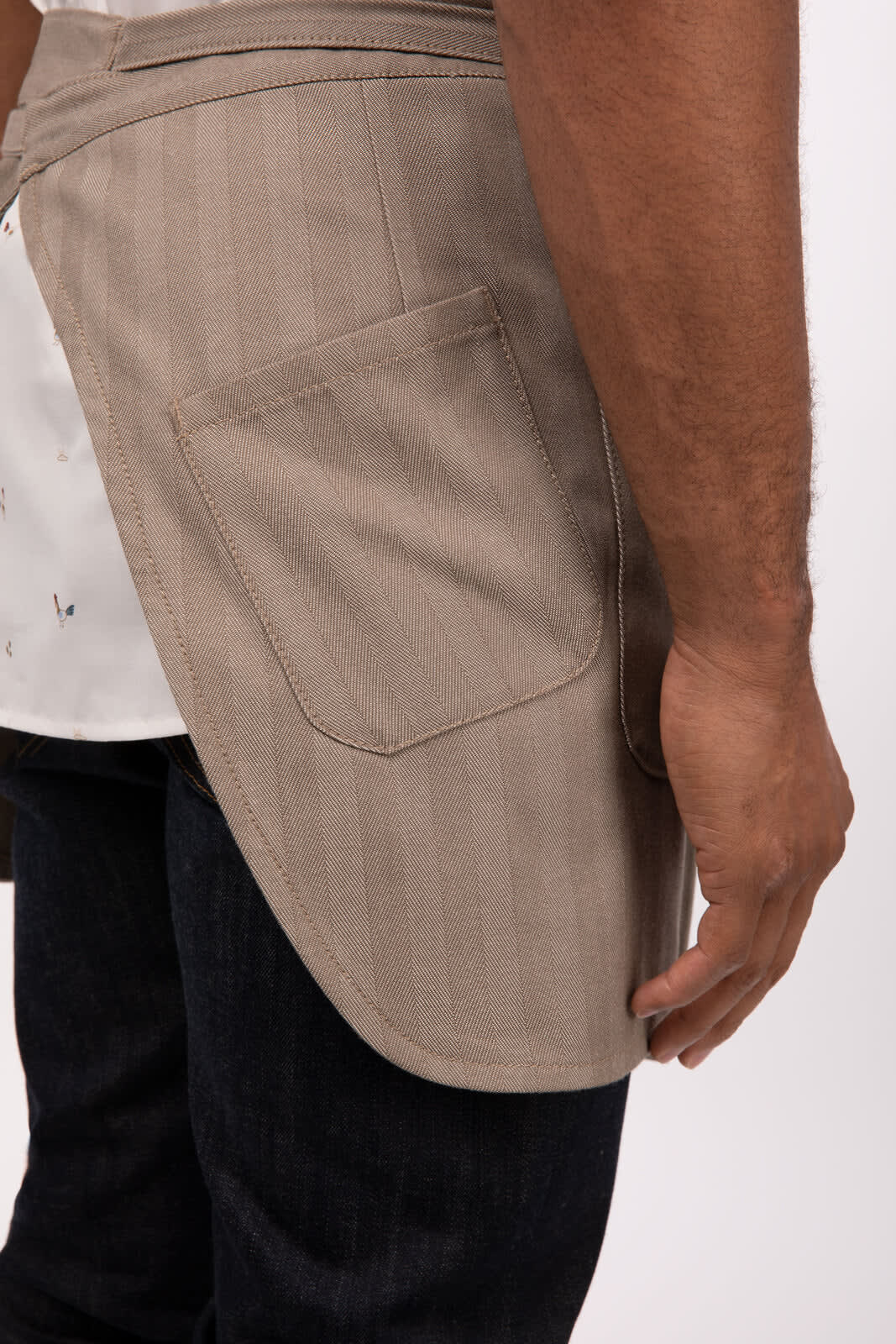 A bistro apron in light beige with a side pocket, featuring a simple design and a striped pattern.