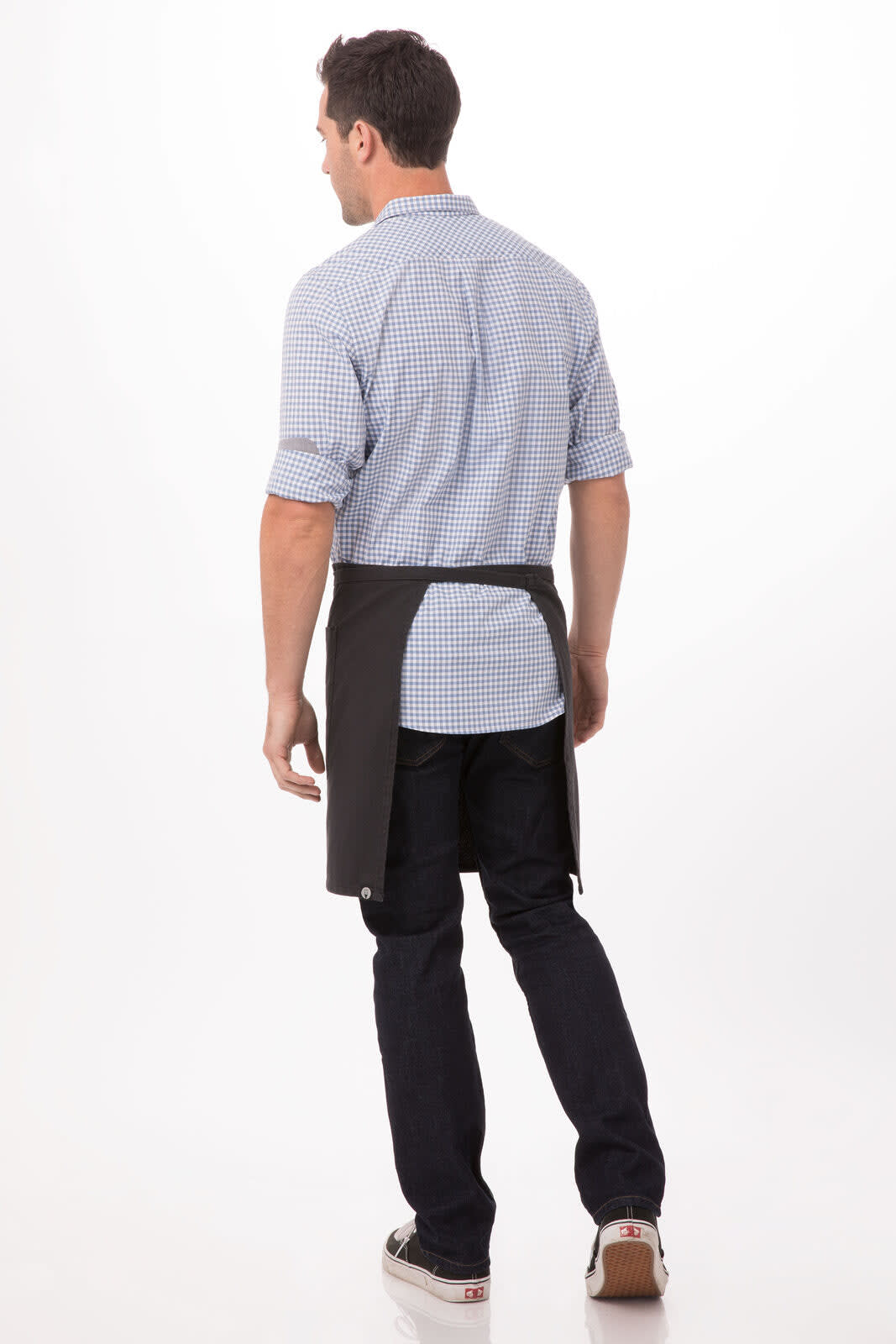 A man wearing a dark grey half bistro apron, with a checkered shirt, facing away from the camera.