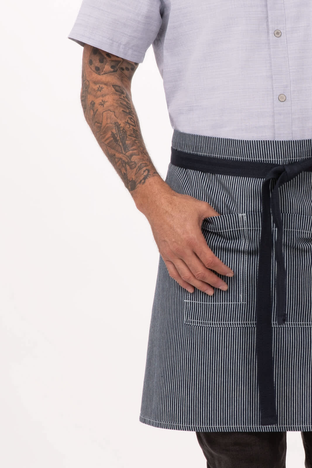A bistro apron in blue and white stripes with a waistband and pockets, worn by a person with tattoos.