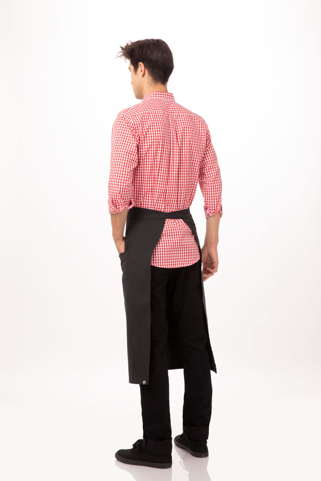 A man wearing a checkered shirt and a black apron, standing with his back facing the camera. The apron has a logo.