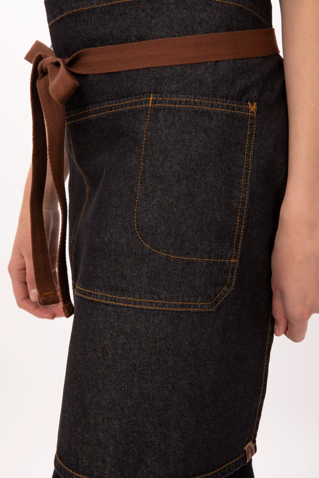 A dark denim bistro apron with a brown waist tie and a side pocket. It features visible stitching and a logo.