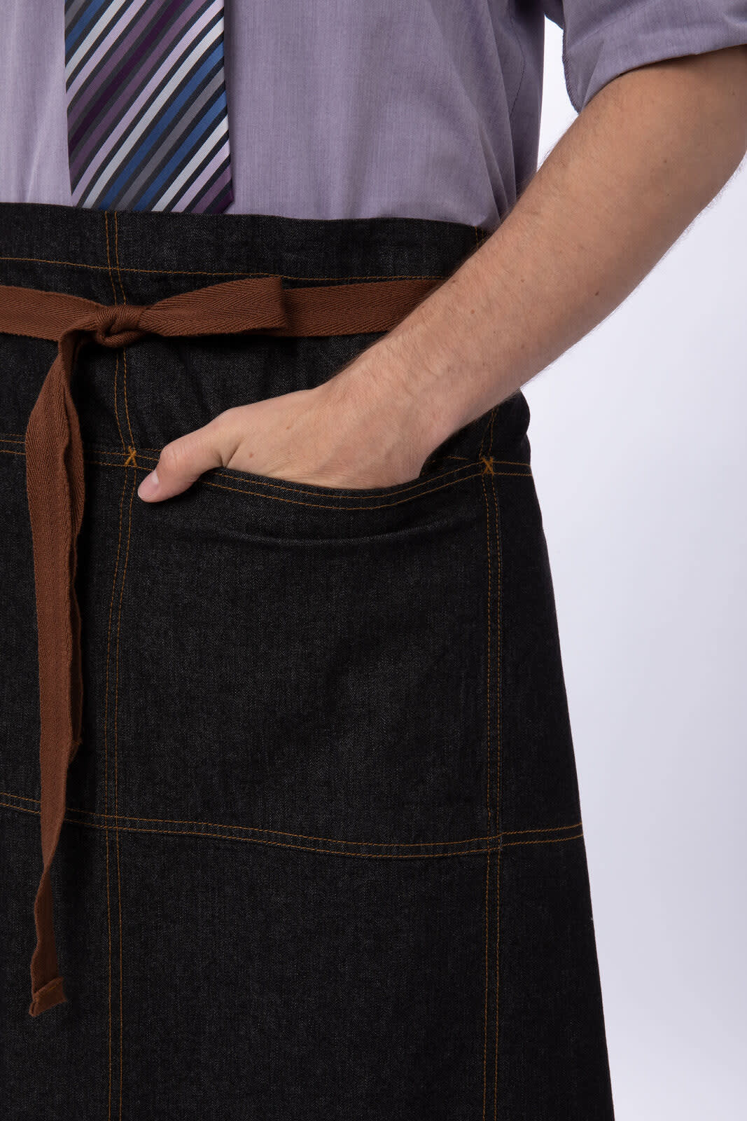A denim bistro apron in dark blue with a brown tie and pocket, featuring a simple design.