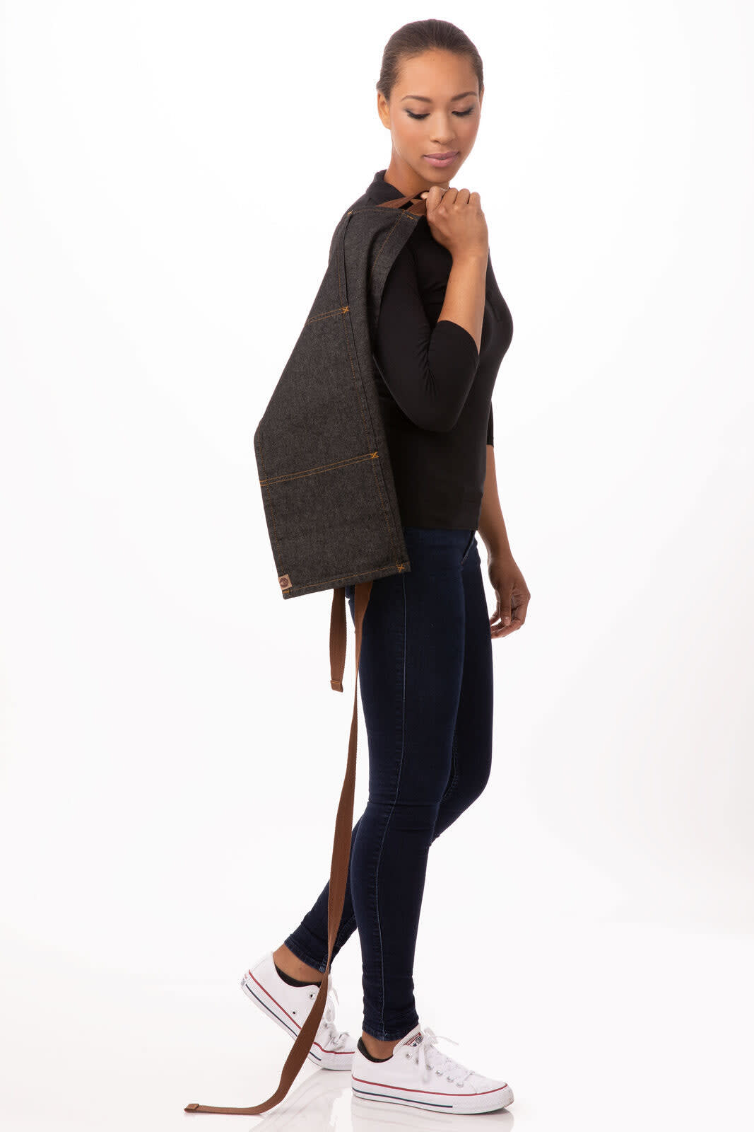 A dark grey waist apron with brown straps, being worn by a model standing sideways.