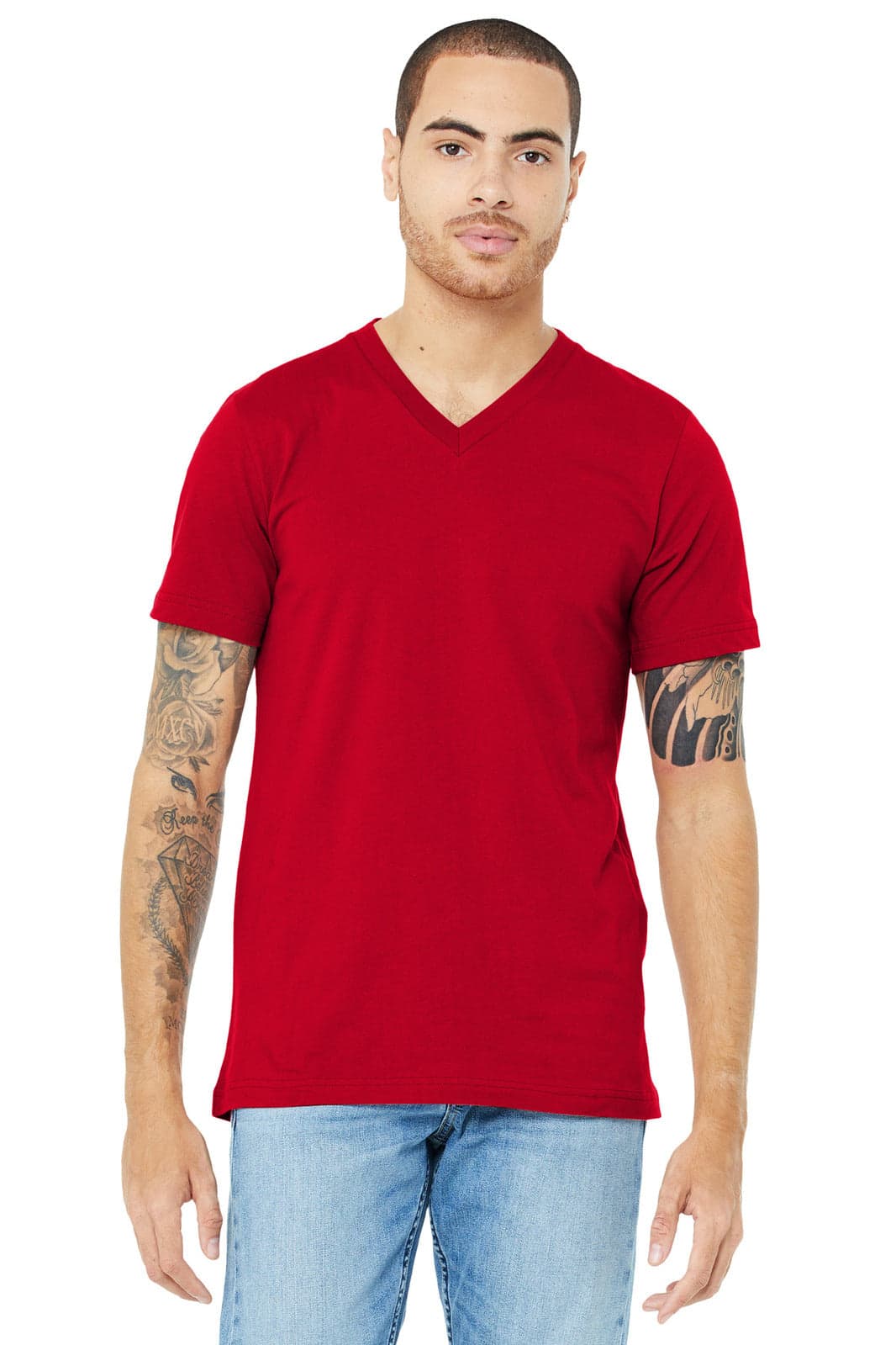 A red unisex jersey short sleeve V-neck tee, displayed on a model with tattoos, featuring a simple design.