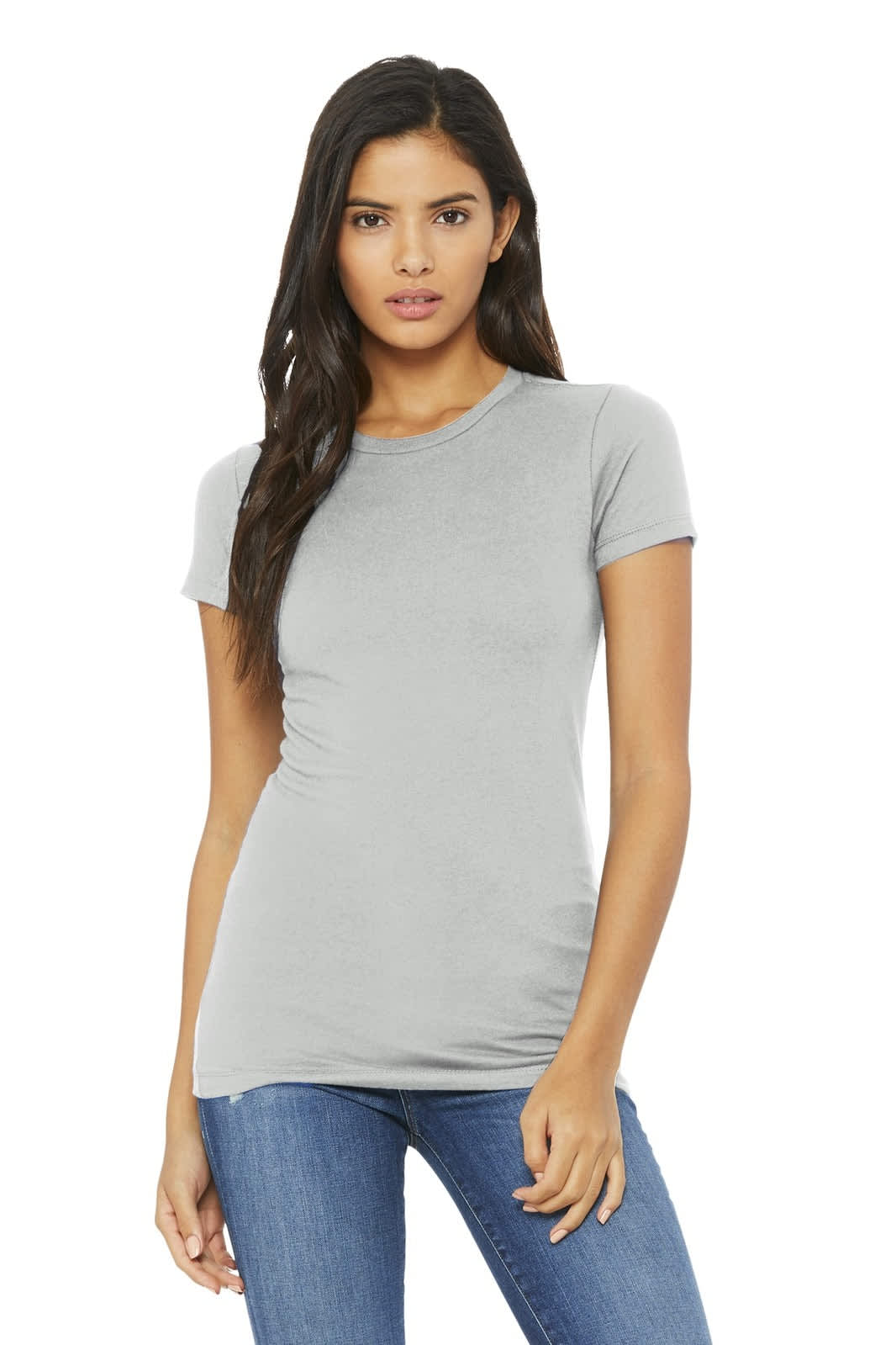 A woman poses in a light grey fitted T-shirt with short sleeves, paired with blue jeans. The shirt features a logo.