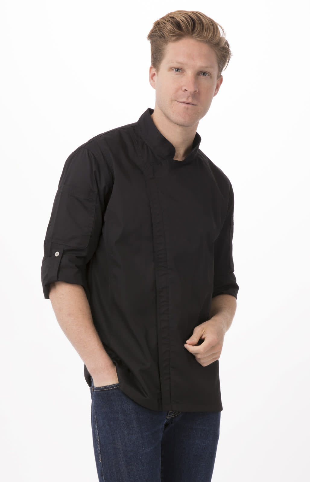 A man wearing a black chef jacket with rolled-up sleeves, standing confidently against a white background.