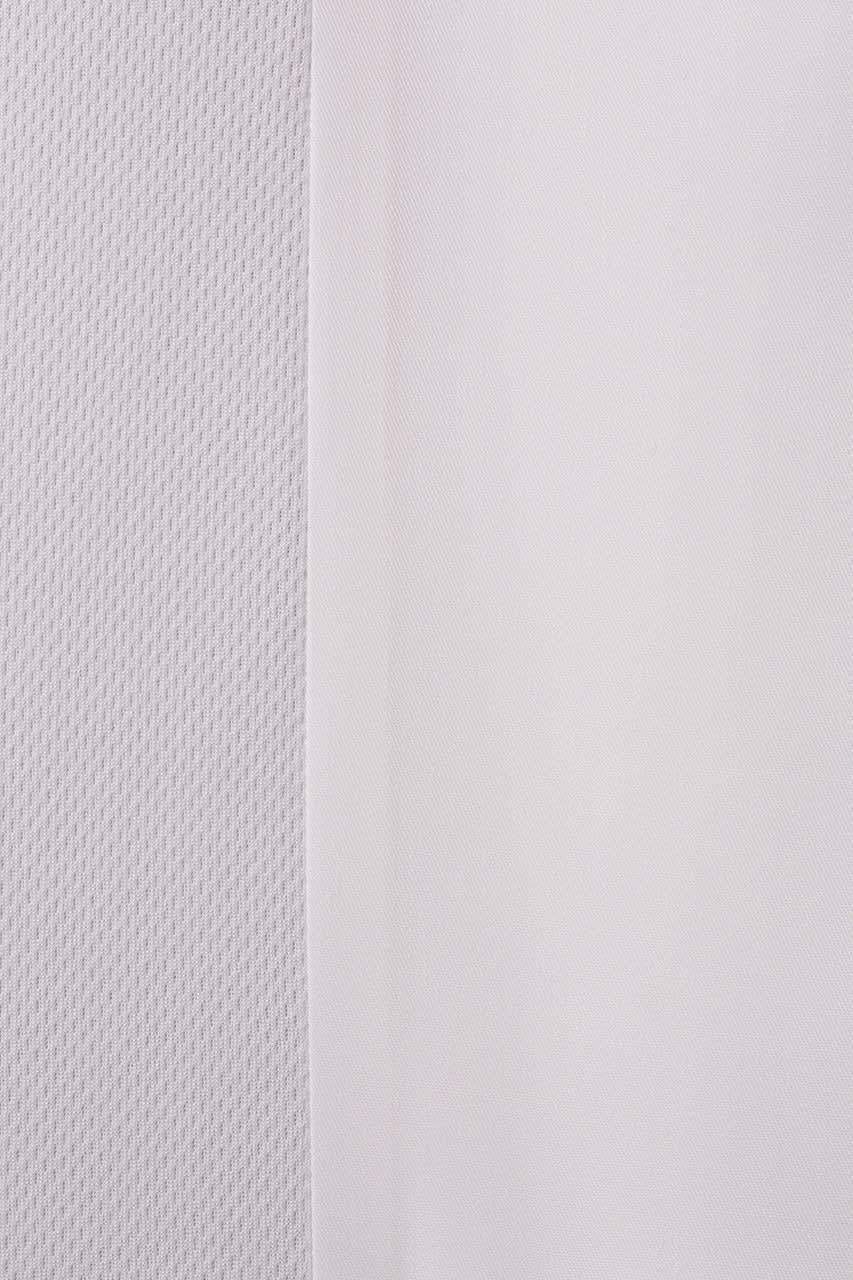 A close-up view of a white fabric with a textured pattern, showcasing different textures and weaves.