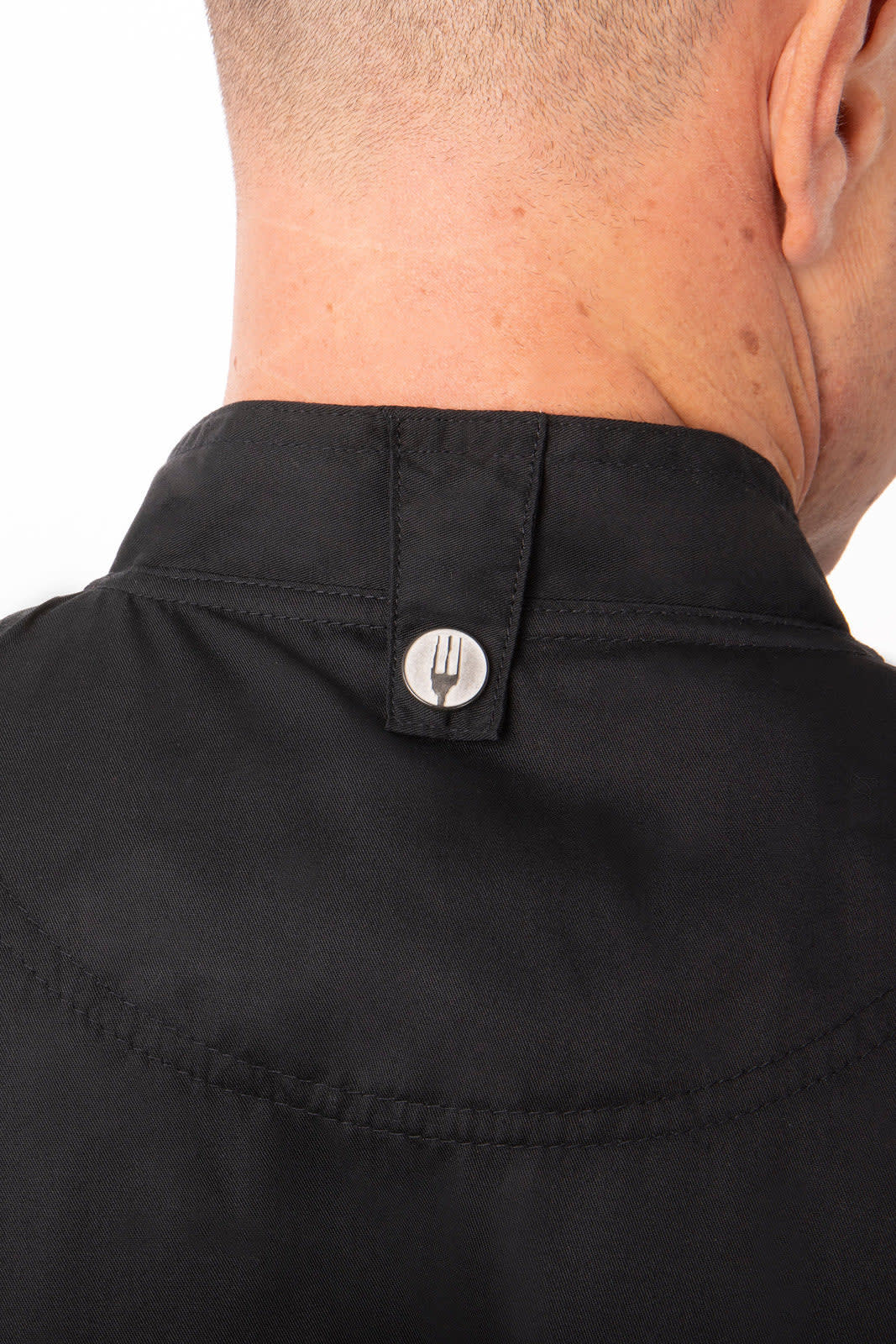 A black chef jacket displaying the back collar with a button detail, featuring branding.