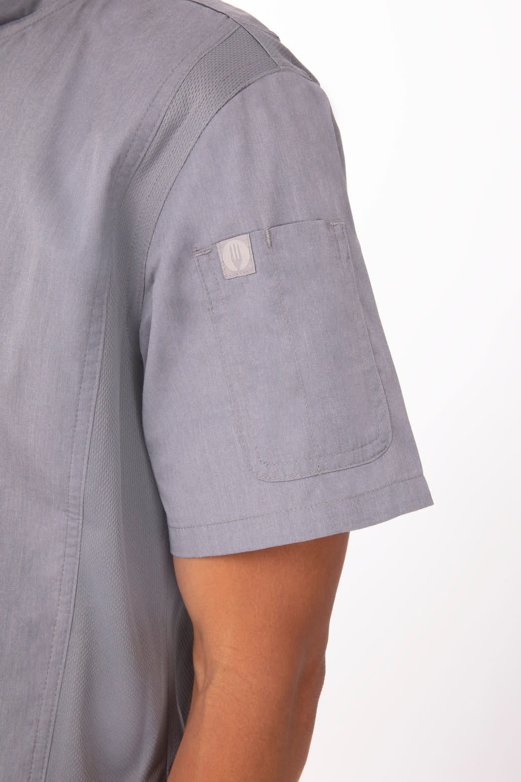 A grey chef jacket featuring short sleeves and a patch on the left shoulder, with a subtle logo.