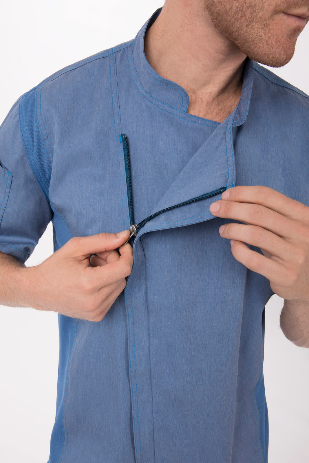 A blue chef jacket with a front zip design, held open by a model showcasing its features.