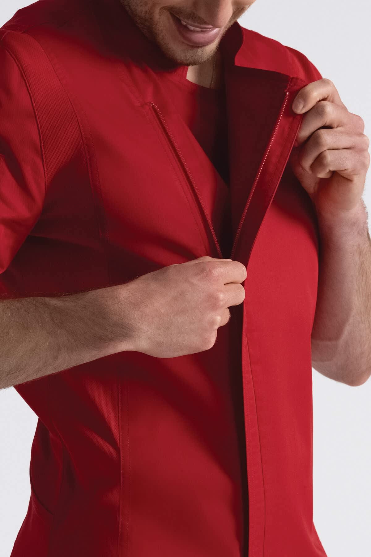 A red chef jacket being worn by a man, featuring a front opening and clean lines. The jacket has a logo.