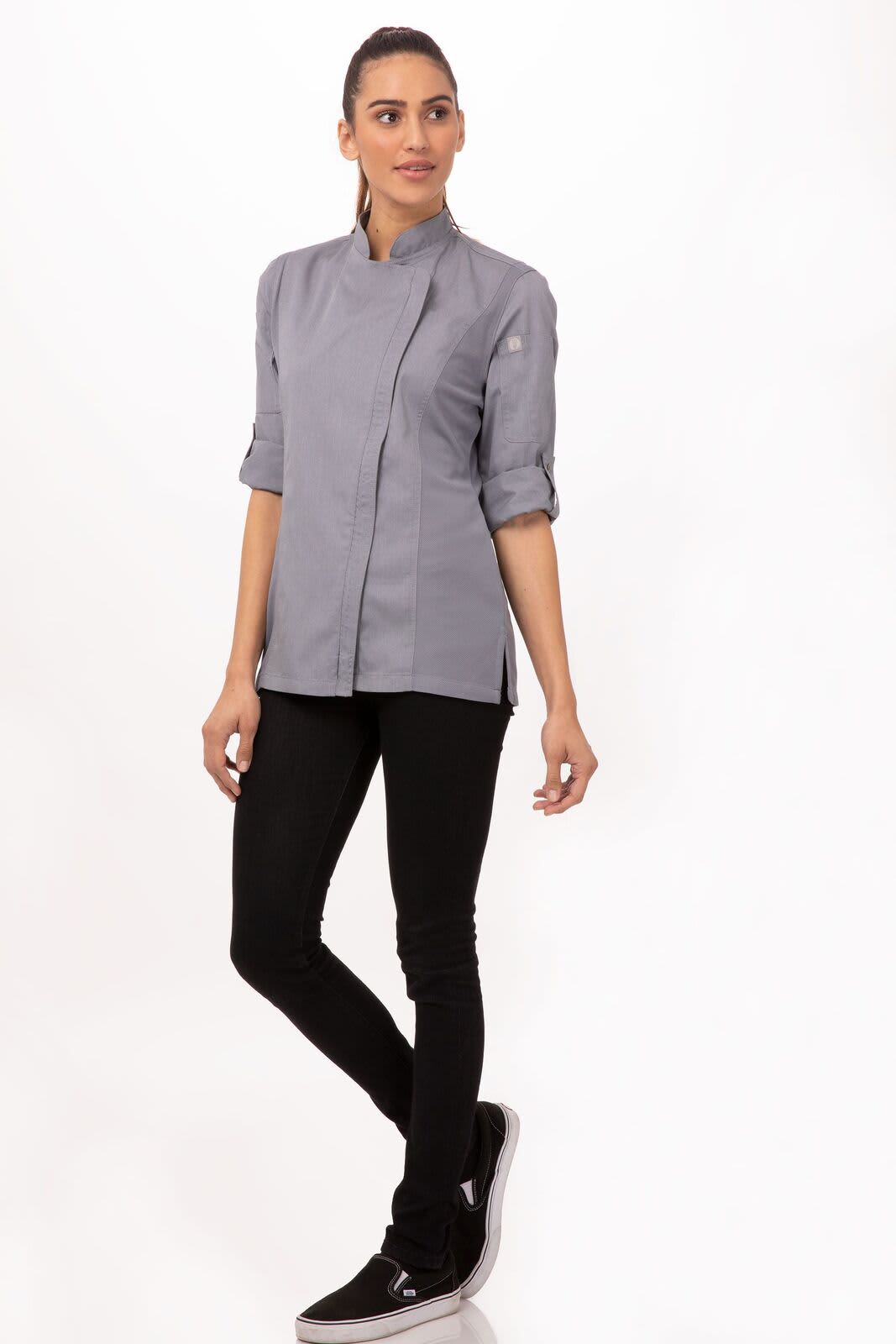 A women's chef jacket in grey, featuring a stand-up collar and rolled sleeves, paired with black pants and sneakers.