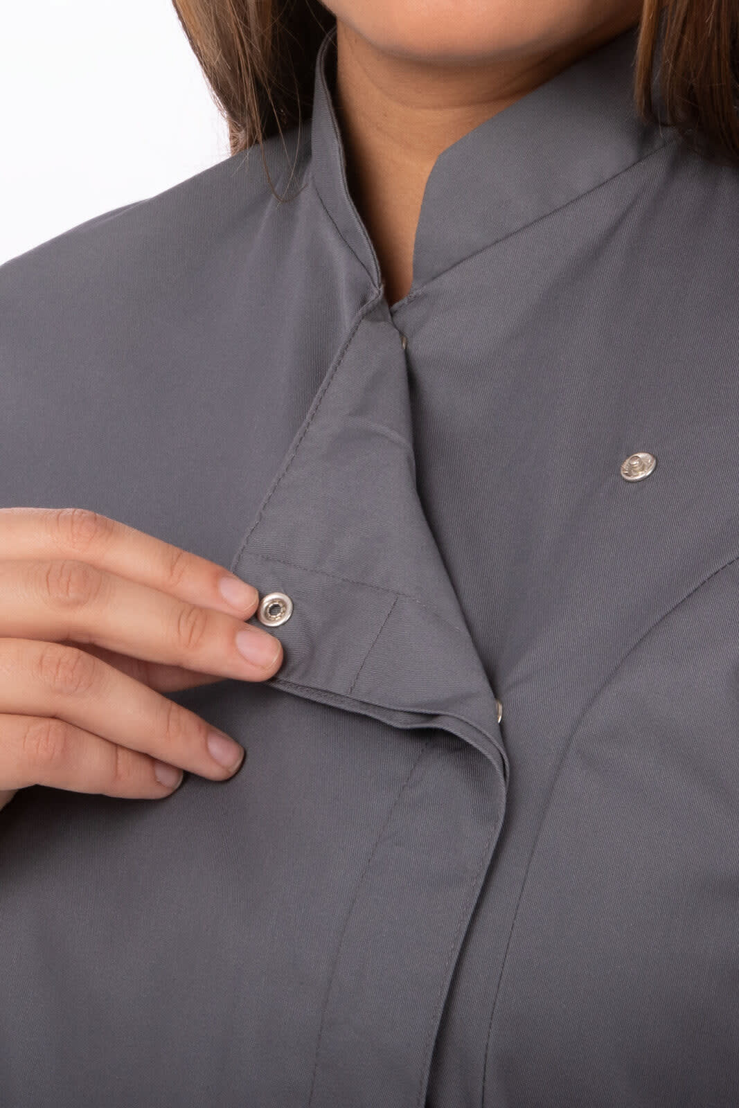 A grey women's chef jacket with a snap collar, featuring a logo and a person adjusting the collar.