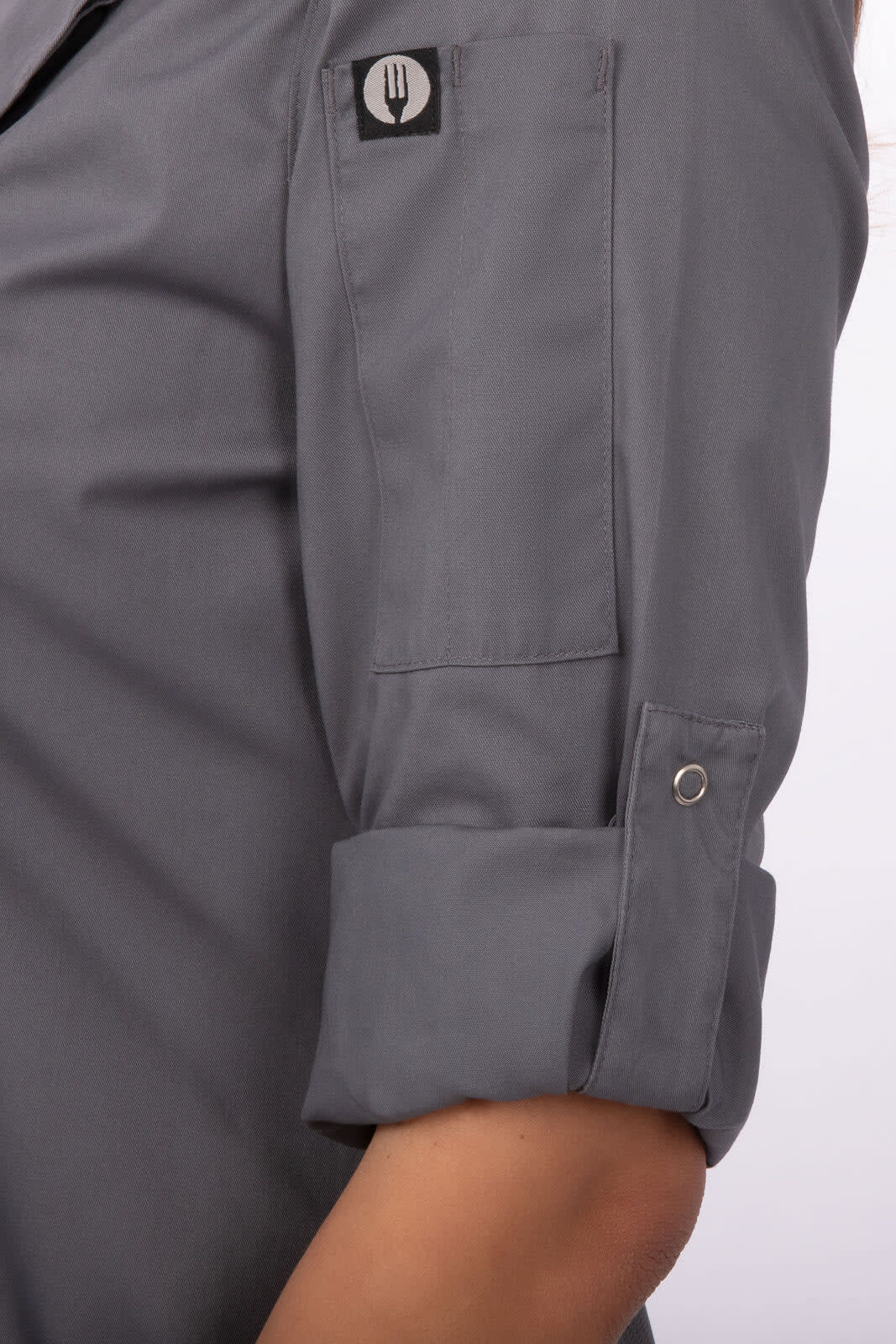 A grey women's chef jacket with rolled sleeves and a logo on the shoulder.