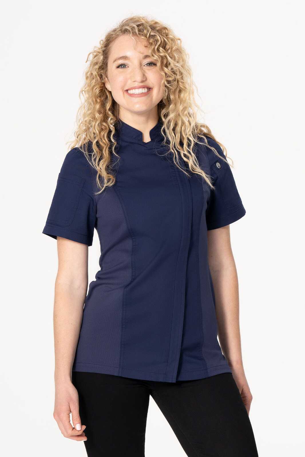 A woman wearing a navy chef jacket with short sleeves and a mandarin collar, featuring a logo.
