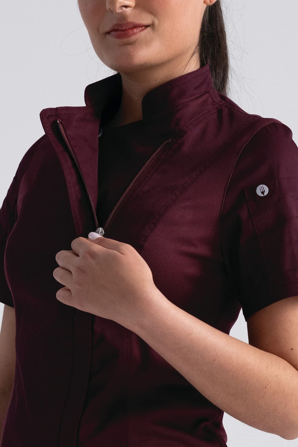 A burgundy women's chef jacket with a zippered front and short sleeves, featuring a logo on the sleeve.