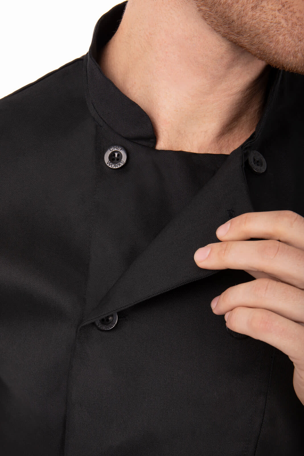 A black chef jacket featuring a stand collar and button closure, with a close-up view of the fabric and fastening.