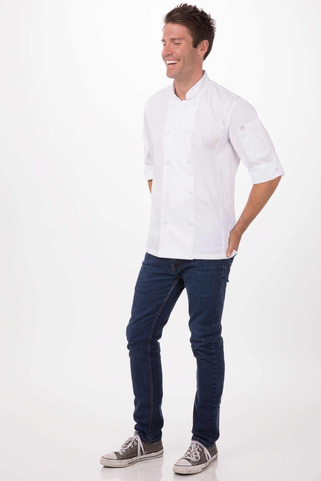 A white chef jacket worn by a man, paired with blue jeans and grey shoes, featuring a logo.