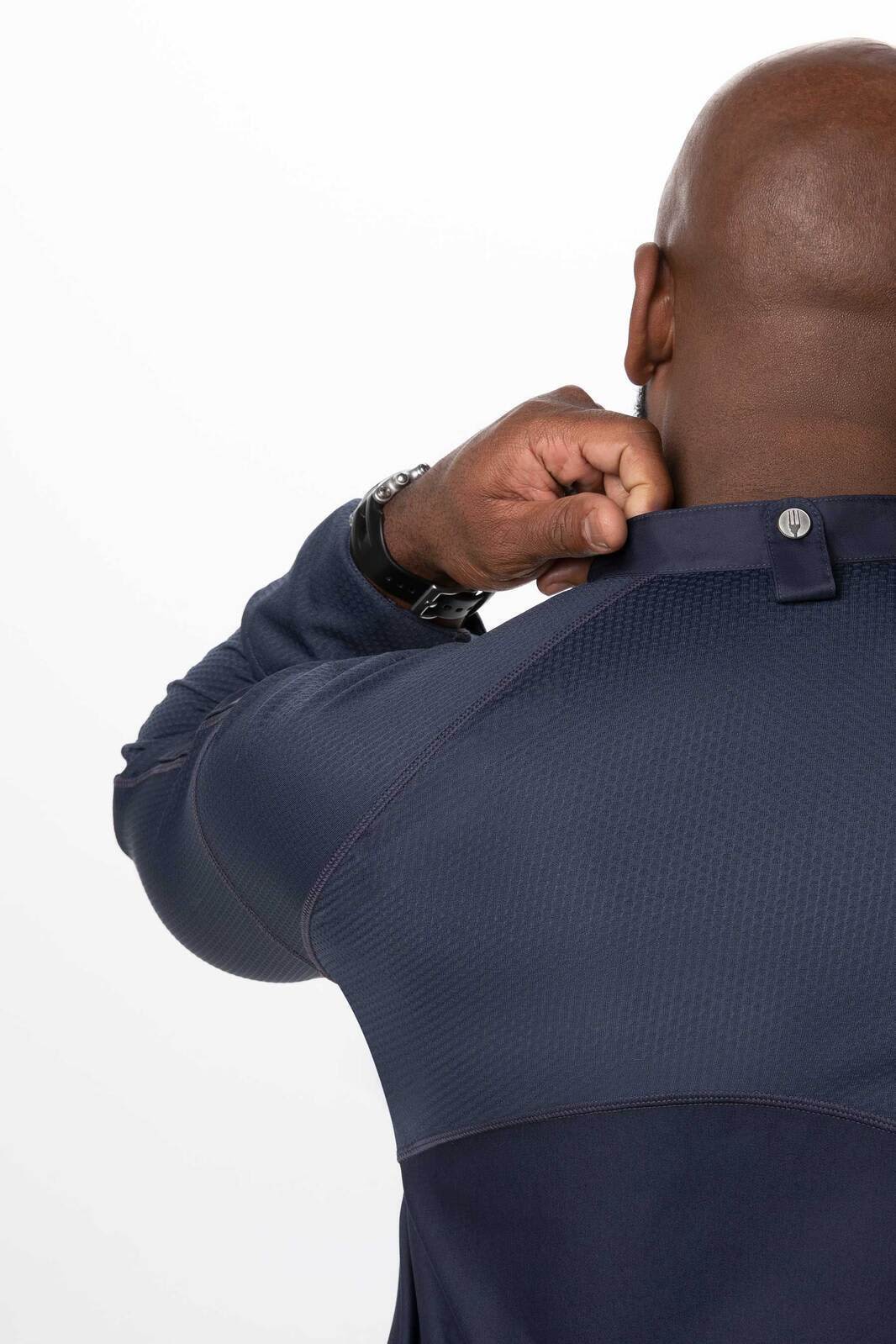 A navy blue men's chef jacket featuring a textured upper and a button closure at the collar, with a logo visible.
