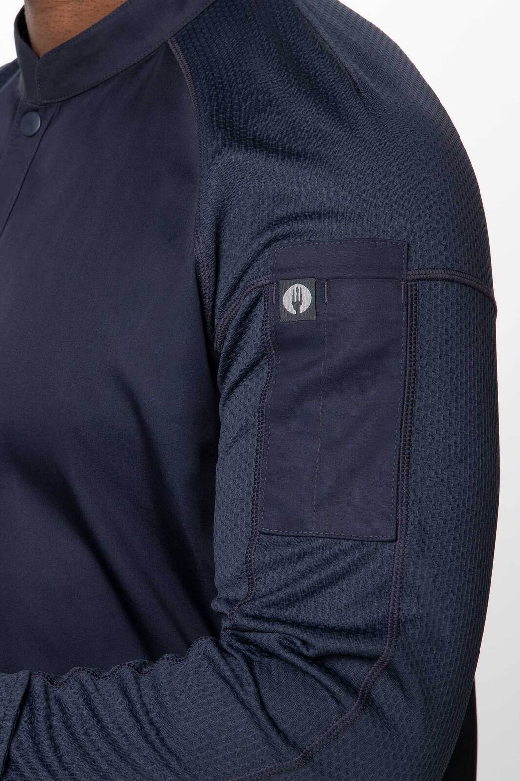 A navy blue men's chef jacket featuring textured fabric and a sleeve pocket, with branding on the pocket.