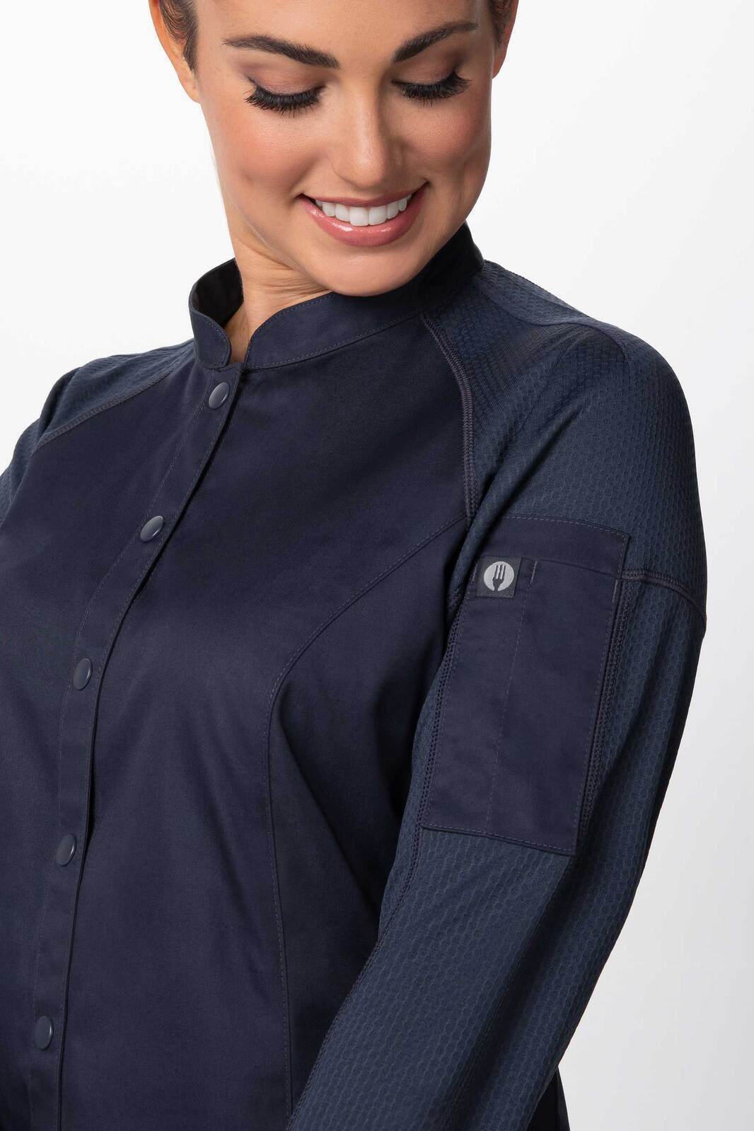 A women's chef jacket in navy, featuring a button-up front and a sleeve pocket, with a logo on the arm.
