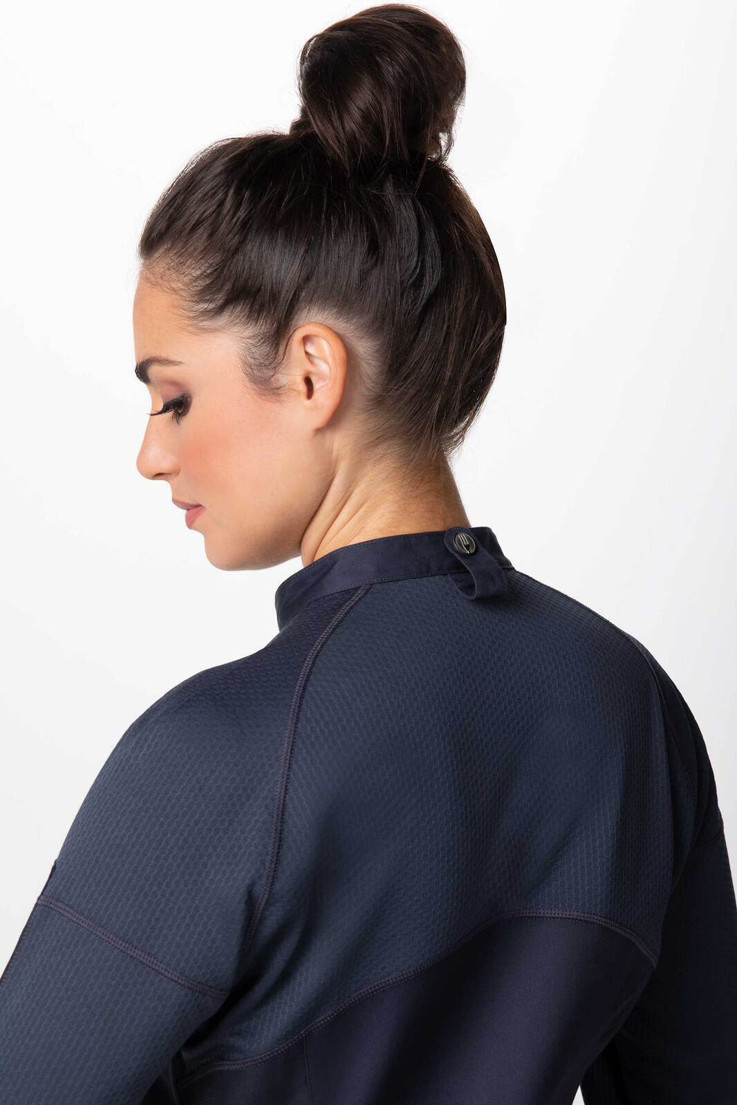 A navy women's chef jacket with a high collar and button detail at the back, featuring a textured design.