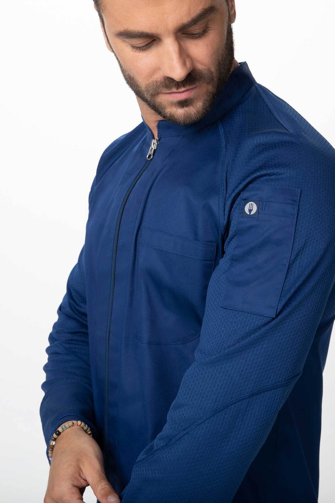 A men's chef jacket in navy blue, featuring a zip front and a patch pocket on the sleeve, with a logo.