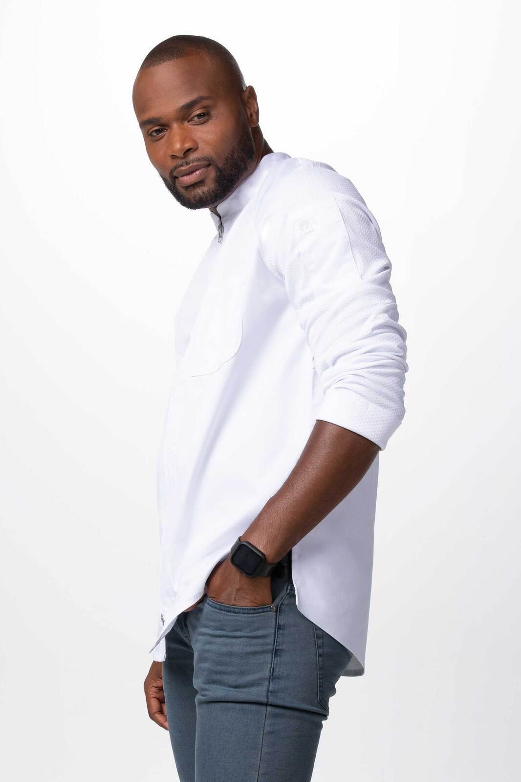 A white chef jacket worn by a man, featuring long sleeves and a sleek design. The model stands confidently.