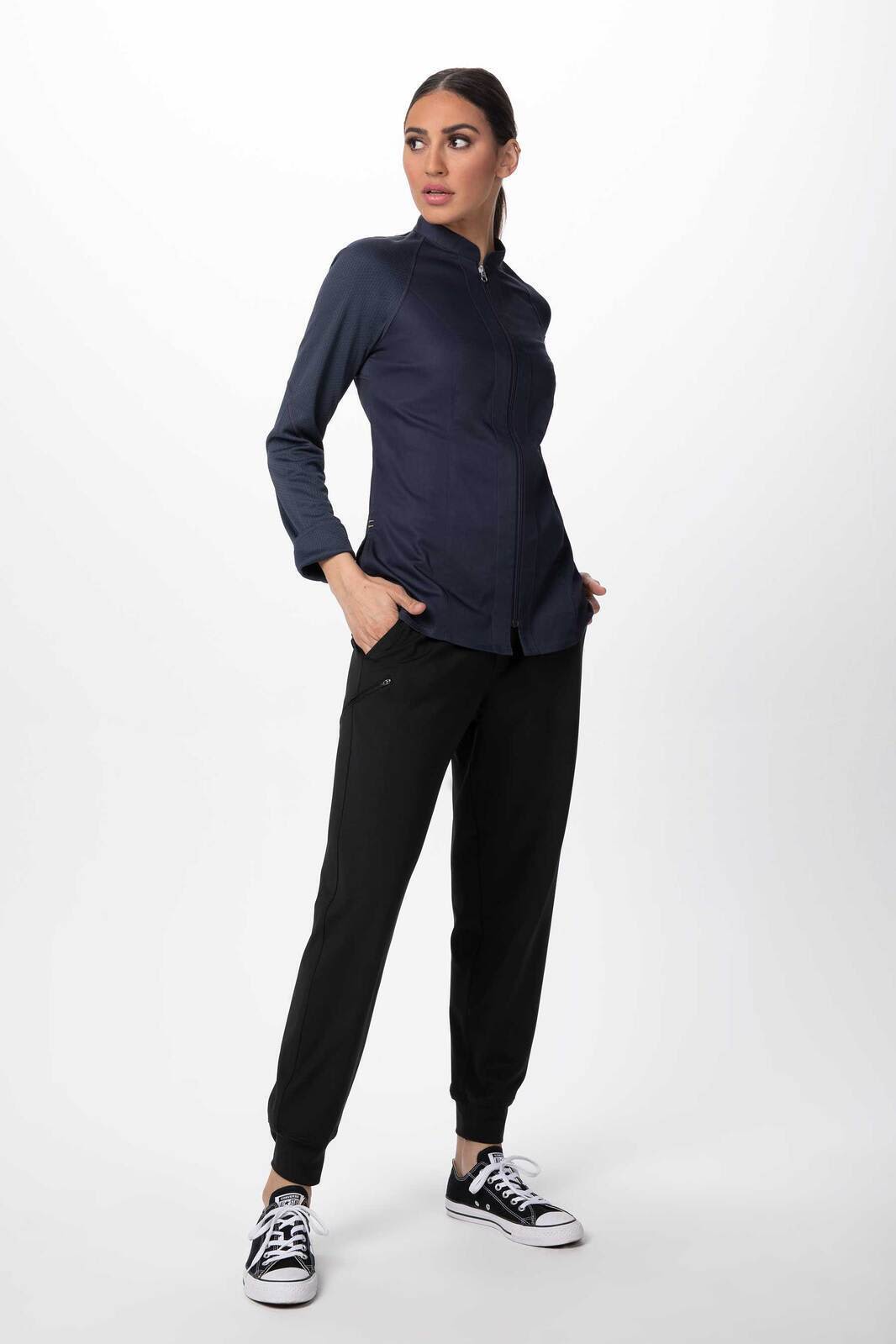 A dark navy women's chef jacket features a stylish collar and pockets, paired with black pants and casual shoes.